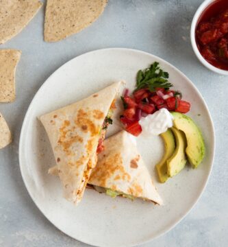 Wrap de pollo chipotle servido con pico de gallo, aguacate y crema agria al lado