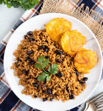 Black beans and rice on a plate garnished with fresh cilantro.