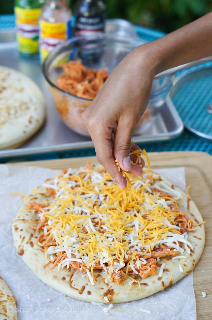 Poniendo el queso en la Mini Pizza de Pollo Buffalo 