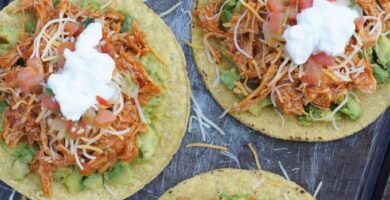 Overhead shot of four tostadas with chipotle chicken topping.