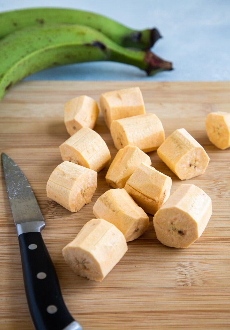 Plátanos verdes siendo pelados a mano, listos para preparar unos buenos tostones caseros.