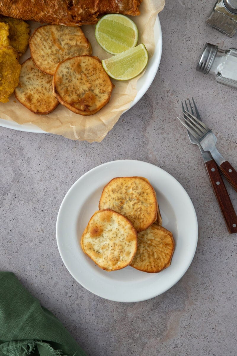 Crujientes papas fritas batata dominicanas, doradas y ligeramente saladas, servidas con lima para obtener el bocado dulce y salado perfecto.