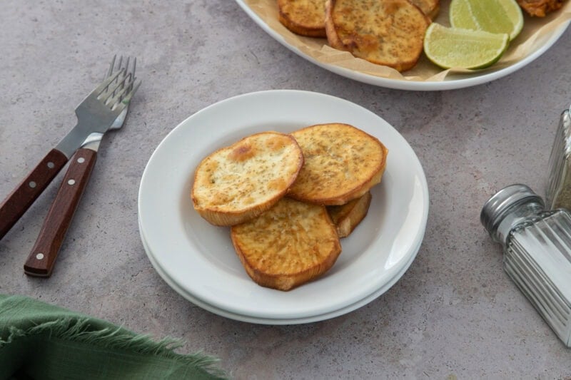 Crujientes papas fritas batata dominicanas, doradas y ligeramente saladas, servidas con lima para obtener el bocado dulce y salado perfecto.